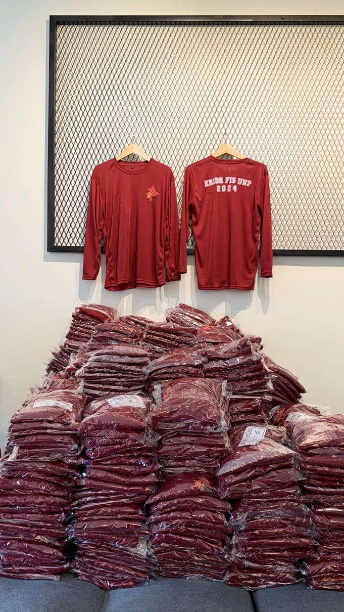 Tumpukan kaos lengan panjang marun yang sudah dikemas plastik