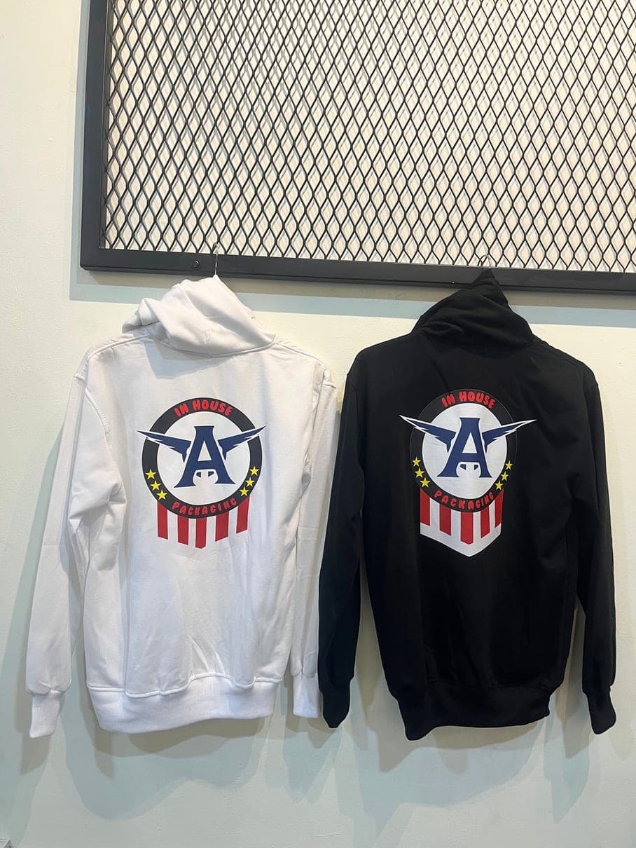 Hoodie putih dan hitam dengan sablon logo besar di punggung