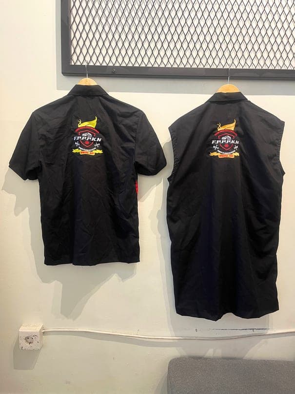 Dua kemeja hitam dengan bordir logo besar di punggung